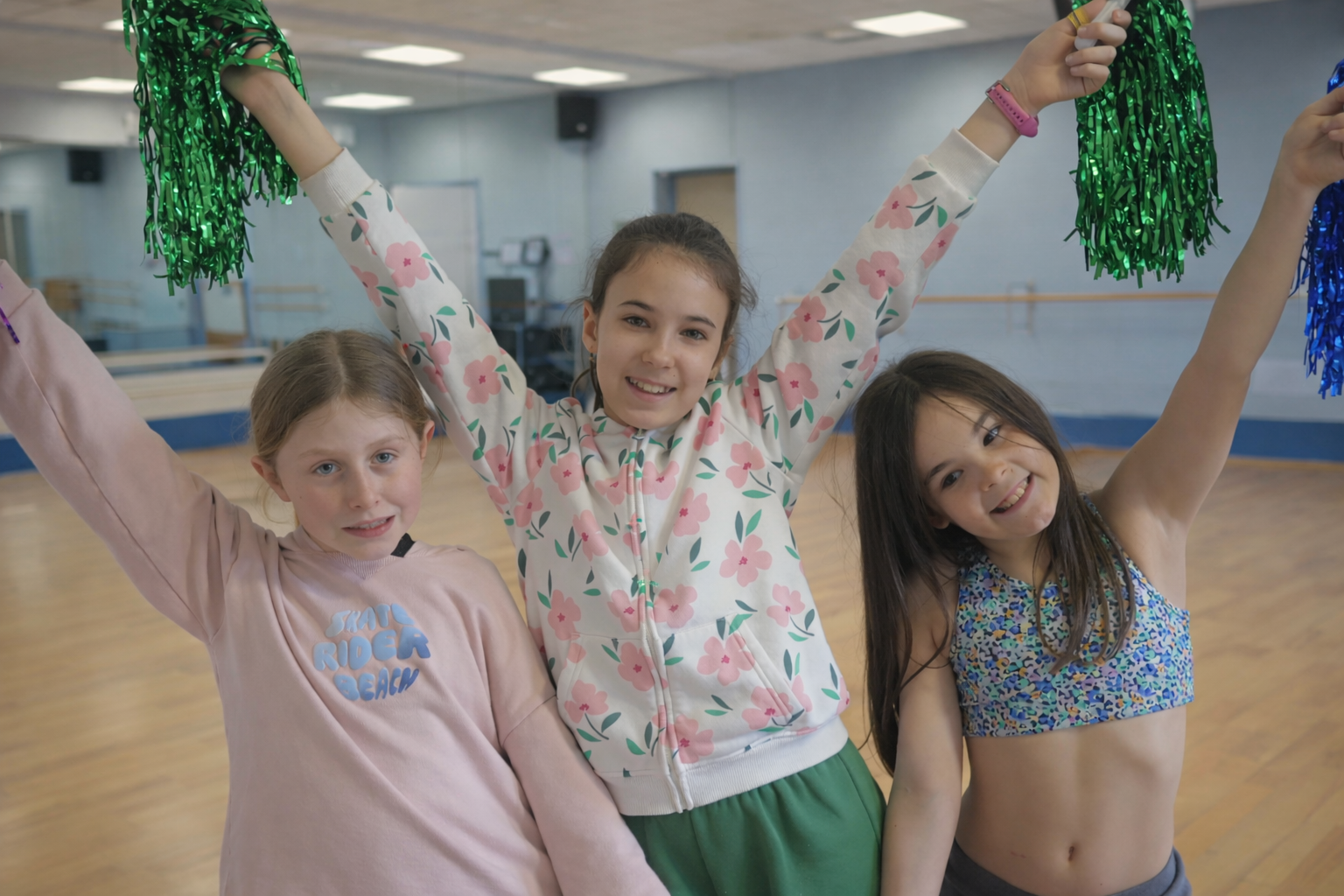 Trois cheerleaders avec pompons colorés
